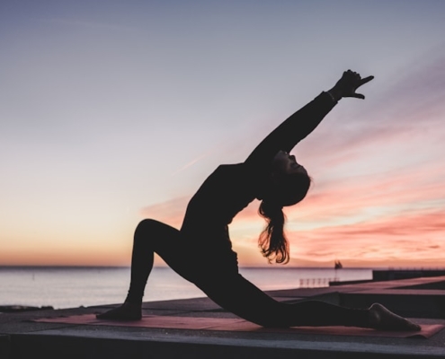 Person practicing yoga at sunset